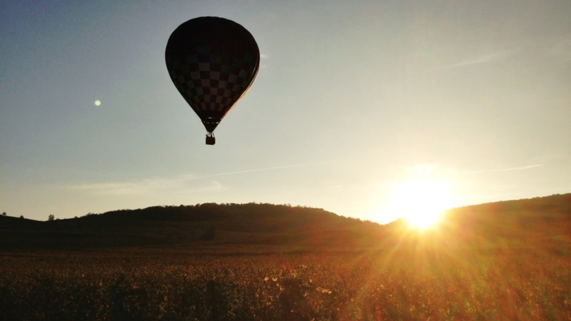 silhouette de montgolfire au soleil couchant