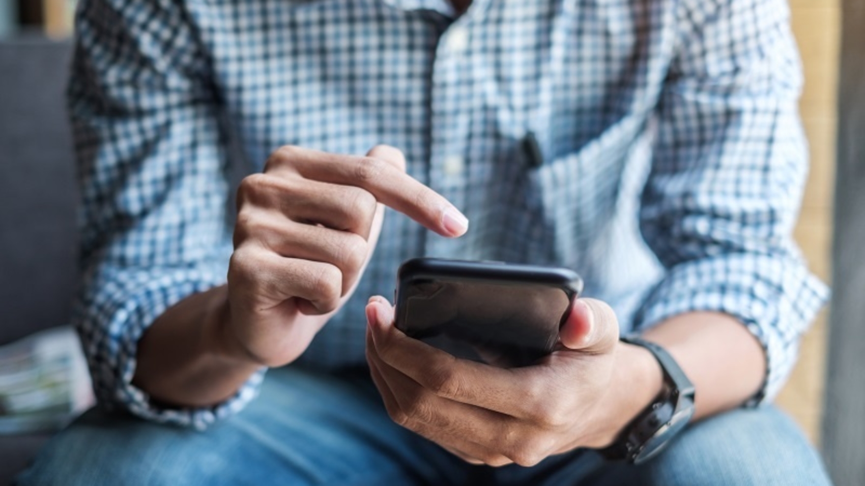 Young casual Businessman holding and using smartphone for sms messages, hipster man typing touchscreen cell phone in the cafe. business, lifestyle, technology and Social media network concept